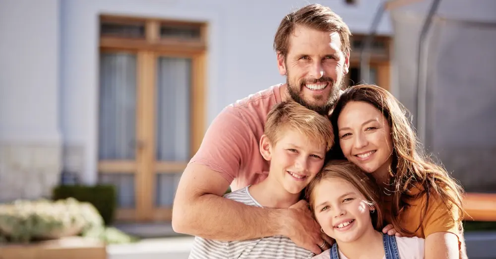 Happy family of four smiling outdoors